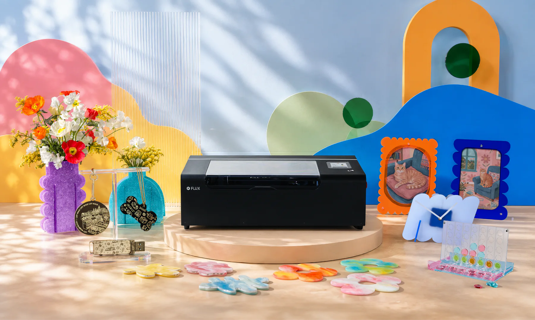 beamo II compact laser cutter displayed with colorful acrylic décor, signs, and accessories