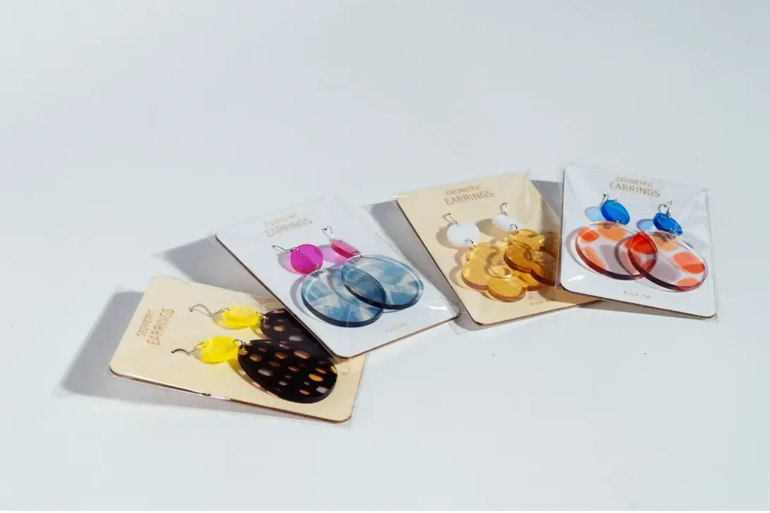 Colorful laser-cut acrylic earrings arranged on product display cards