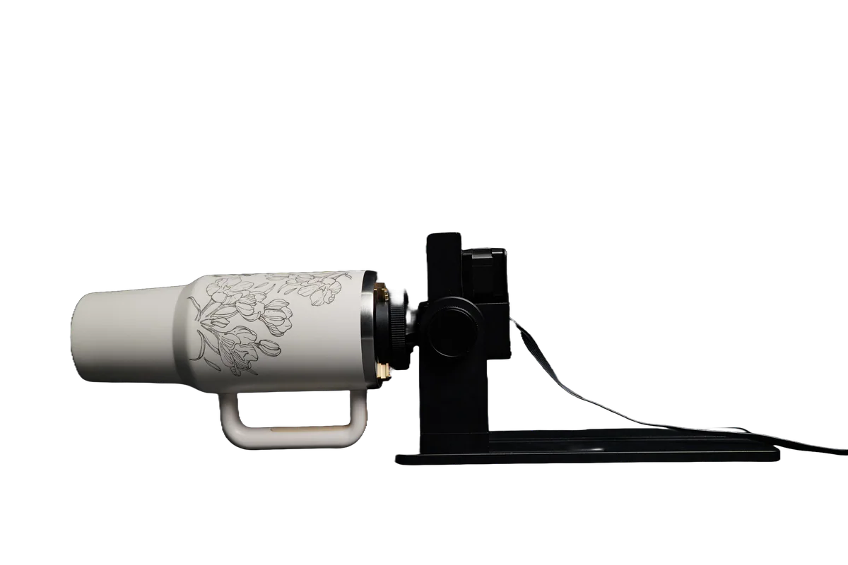 Custom engraved tumbler mounted in a rotary fixture