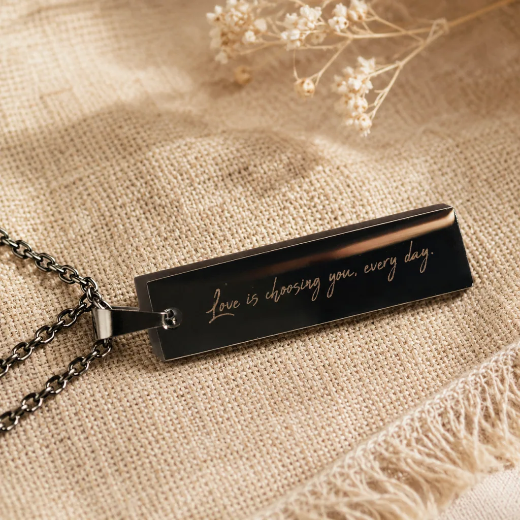Black metal pendant with fine script engraving