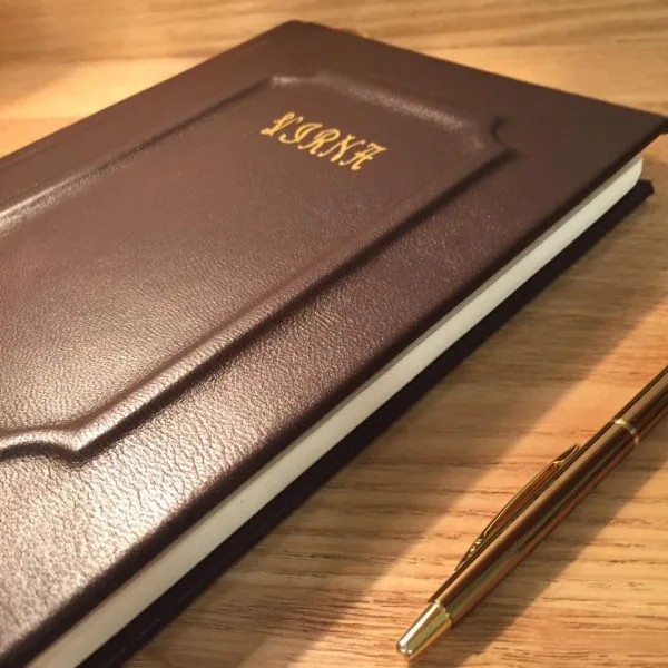 Gotowy brązowy skórzany notes na drewnianym stole